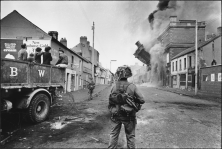 Un soldat britannique devant un immeuble en feu. Irlande du Nord, 1969