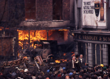Un homme tente de calmer la foule des manifestants devant un immeuble en feu. Londonderry. Irlande du Nord, 1969