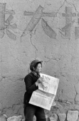 Jeune fille lisant le journal de la Jeunesse Chinoise avec des baguettes, Province du Shanxi, Chine, 1965